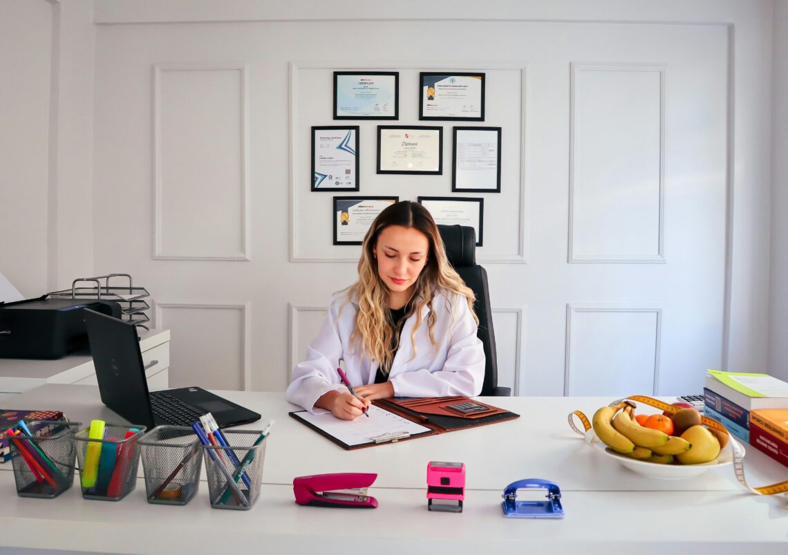 Doctor creating a personalized medical weight loss plan in a Salt Lake City clinic office with healthy food and measuring tape on desk