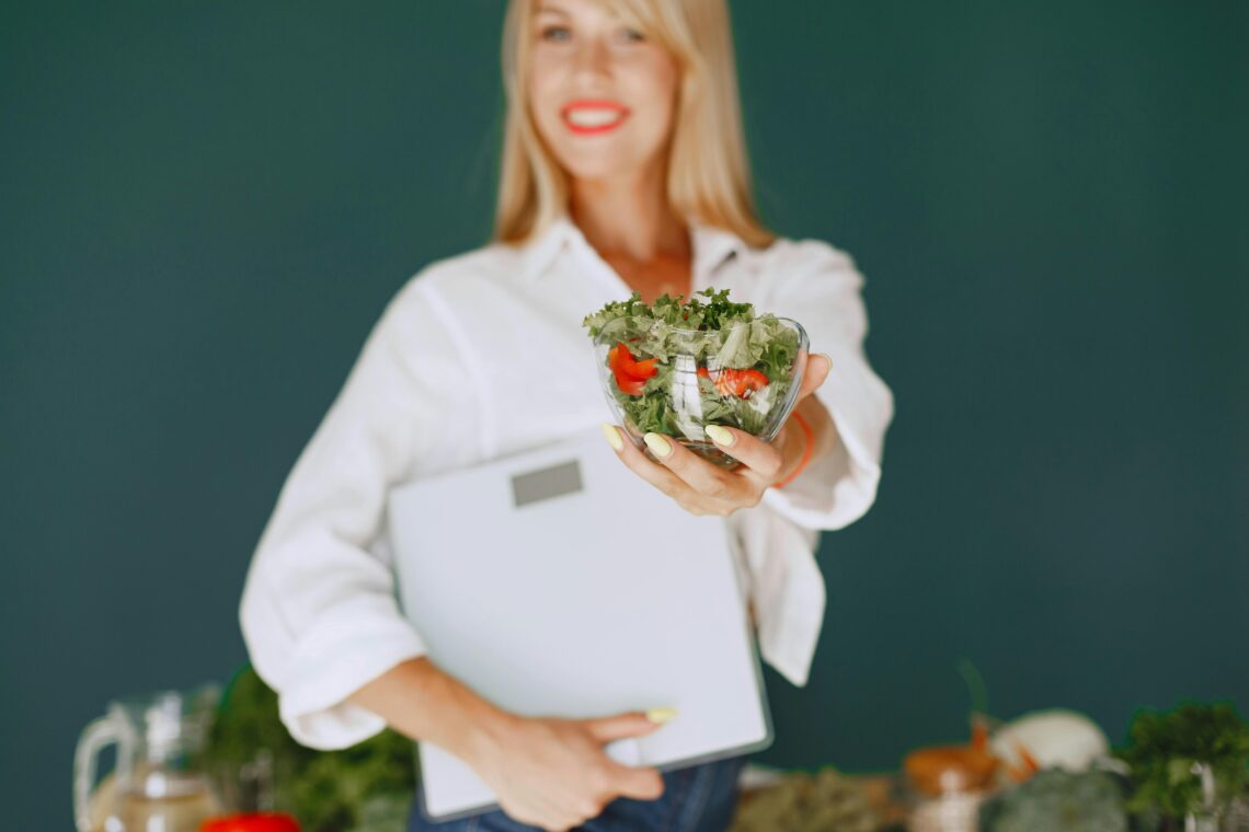 Female healthcare provider holding a bowl of fresh salad and tablet to represent medically supervised GLP-1 weight loss therapy and nutrition support in Utah.